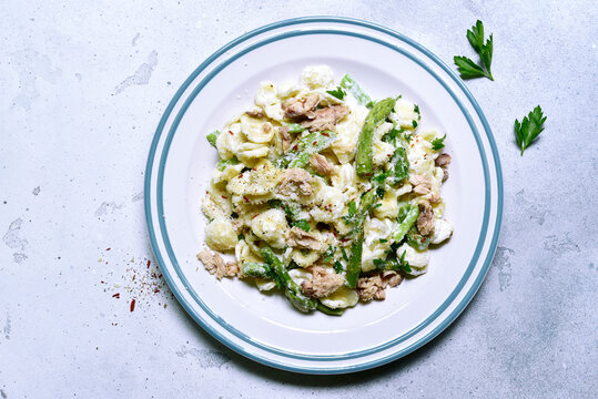 Pasta orecchiete with tuna and asparagus in a cream sause. Top view with copy space.
