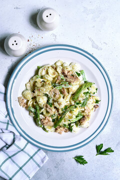 Pasta orecchiete with tuna and asparagus in a cream sause. Top view with copy space.