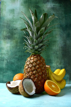 Different types of exotic fruits : pineapple, coconut, banana, orange, persimmon and pomegranate.