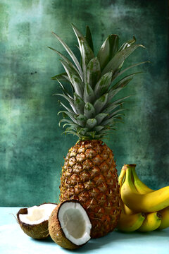 Different types of exotic fruits : pineapple, coconut, banana, orange, persimmon and pomegranate.