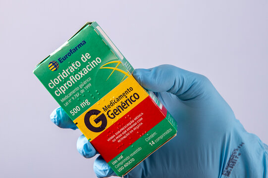 Gloved hand holding generic ciprofloxacin medicine box