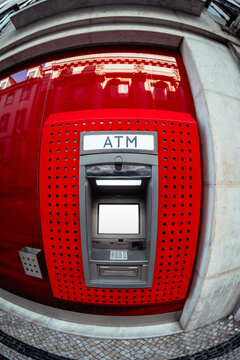 Blank display on a red automated teller machine photographed with dramatic fisheye distortion, offering a vivid editable finance, banking, cash withdrawal or advertising template
