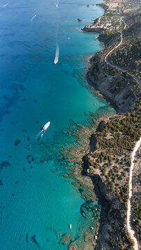 Akamas coastline, aerial view with boats sailing on turquoise sea in Cyprus