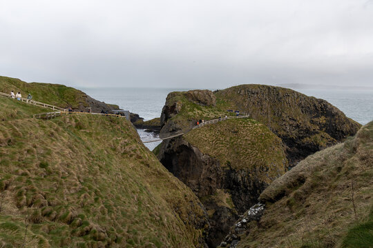 Iconic Carrick-a-Rede Rope Bridge connecting rocky cliffs along the famous Causeway Coastal Route near Ballintoy in County Antrim, Northern Ireland.