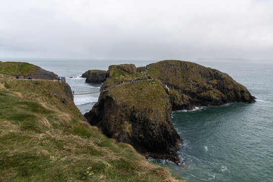Iconic Carrick-a-Rede Rope Bridge connecting rocky cliffs along the famous Causeway Coastal Route near Ballintoy in County Antrim, Northern Ireland.