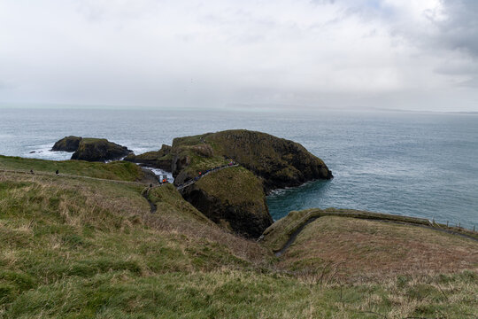 Iconic Carrick-a-Rede Rope Bridge connecting rocky cliffs along the famous Causeway Coastal Route near Ballintoy in County Antrim, Northern Ireland.