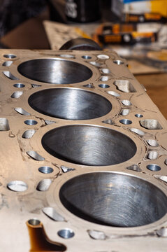 Top view of an automotive engine block showing four cylinder bores and various fluid passages for vehicle repair and maintenance