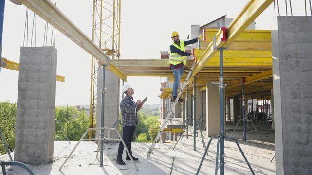 Architect and construction worker supervising building site
