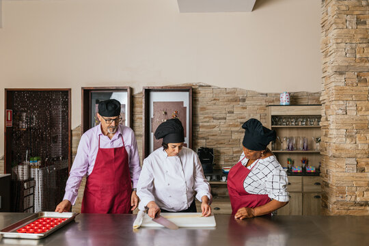 Chefs preparing dessert during cooking course in restaurant kitchen
