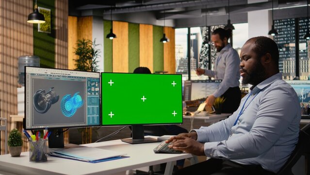 R&D expert researches eco-friendly materials for power generation gear on a mockup computer while a renewable energy technician upgrades a turbine.