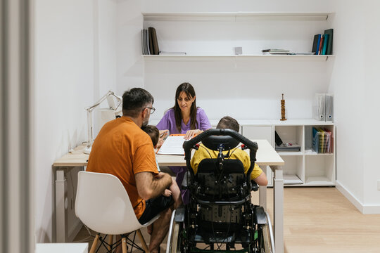 Doctor explaining medical chart to family with child with disability