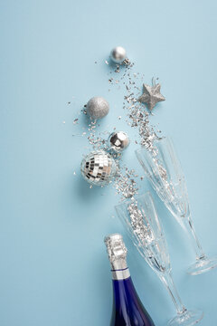 Happy New Year 2027 celebration with champagne flutes, silver ornaments and confetti on blue vertical background