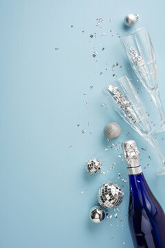 Happy New Year 2027 celebration with champagne bottle, flute and silver holiday decoration on blue vertical background