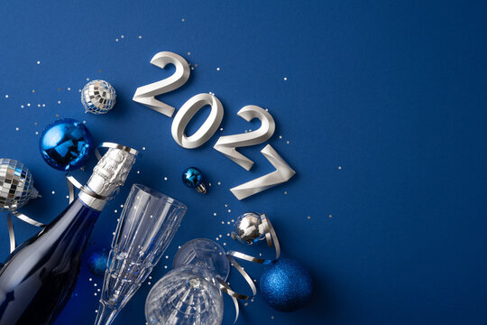 Happy New Year 2027 celebration with blue ornaments, champagne bottle and festive party decorations