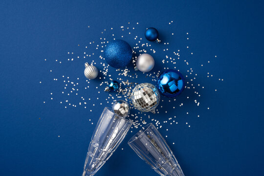 Happy New Year 2027 celebration with blue and silver ornaments champagne glasses and confetti on blue background