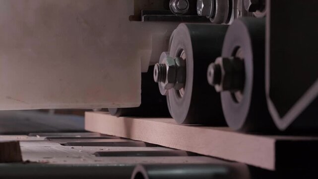 Close-up of industrial automated CNC woodworking machine cutting wood component in modern furniture factory
