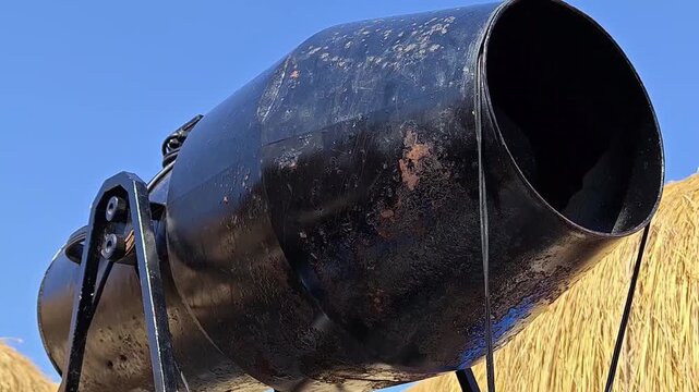 Rustic old metal cannon against a blue sky background