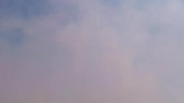 Vibrant pink smoke clouds against a clear blue sky: energetic abstract nature imagery