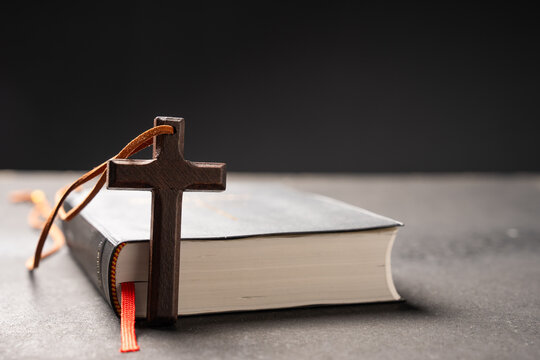 Wooden cross with the Bible and Holy Scripture