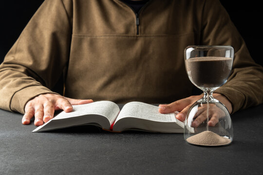 A man spends time reading the Bible hourglass