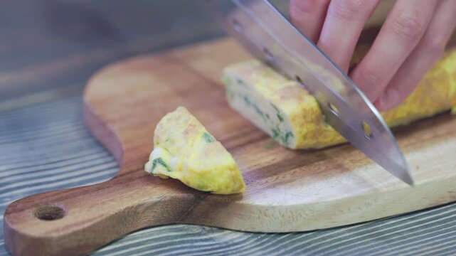Fresh Rolled Omelette 01- Slicing on Wooden Board.
A close-up shot of a chef slicing freshly cooked Korean rolled omelette (Gyeran-mari) with a knife on a wooden cutting board. Ideal for cooking tutor