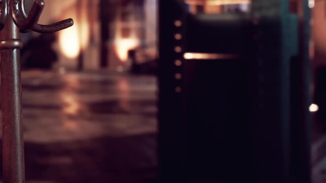 A key holder stands in focus while the background is out of focus. Light falls softly in the background. The setting appears to be indoors at night.