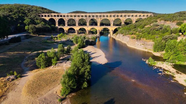 Aerial drone view of the Pont du Gard, the tallest surviving ancient Roman aqueduct from the 1st century with three tiers of arches, France. High quality 4k footage