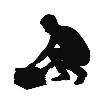 Man crouching to pick up stack of books silhouette
