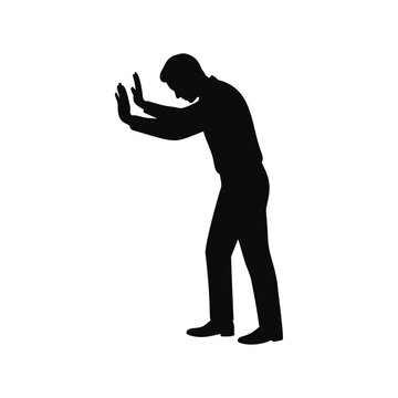 Silhouette of man pushing against invisible wall