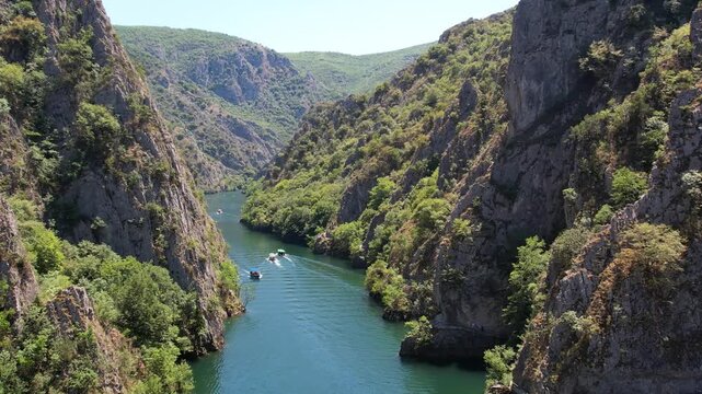 Mountains and pleasure boats in Matka Canyon Skopje, North Macedonia. Drone view of Matka Canyon. Drone shot of a lake in a canyon in North Macedonia. Aerial panoramic drone view from above, top view 