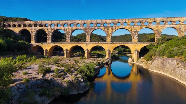 Aerial drone view of the Pont du Gard, the tallest surviving ancient Roman aqueduct from the 1st century with three tiers of arches, France. High quality 4k footage