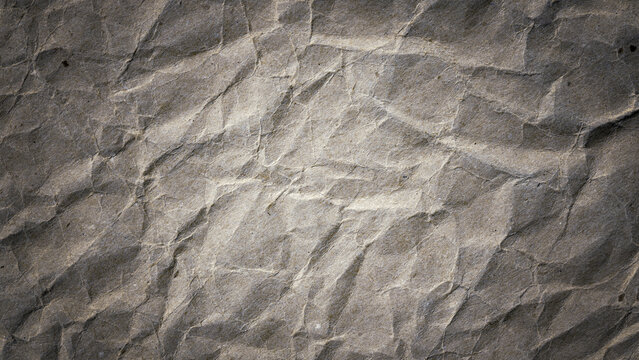 Crumpled gray paper with darkened edges background. 