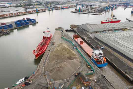 Red and Blue Cargo Ships Docked at the Port of Middlesbrough During a Cloudy Day in England