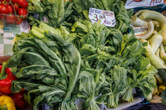 Fresh raw green spinach at a vegetable stand at a farmers market, Sanremo, Italy