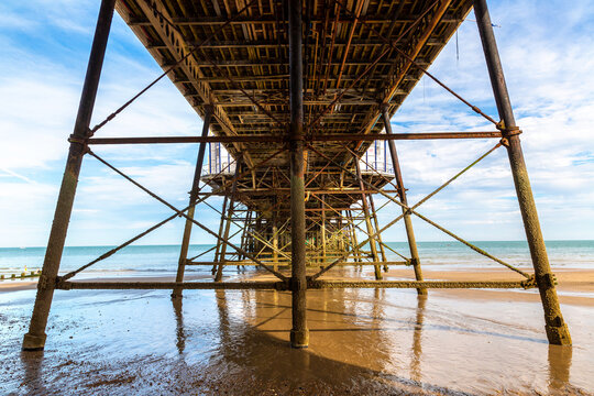 Under Eastbourne Pier on Sandy Beach in Eastbourne, East Sussex, England, UK