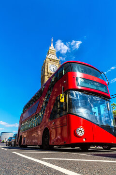 Red double decker bus on Westminster Bridge with Big Ben clock tower and Palace of Westminster in London, England, UK