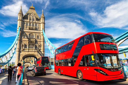 Public Red double decker bus crossing Tower Bridge over River Thames in London, England, UK