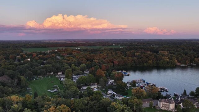  Aerial Autumn View of Wooded Lakeside Neighborhood, Lauderdale Lakes, Wisconsin Aerial drone view over a wooded lakeside neighborhood in autumn near Elkhorn, Wisconsin, at dusk. Colorful fall foliage