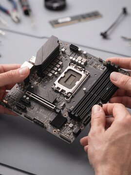 Hands Holding Modern Computer Motherboard