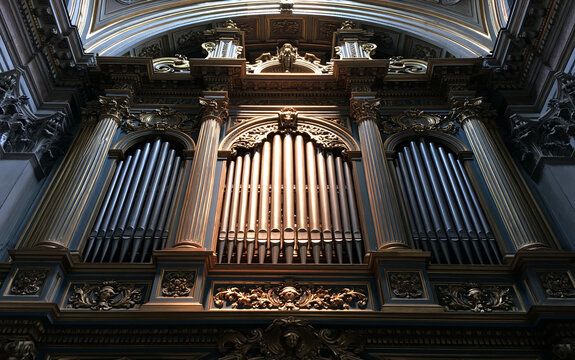 Long metal pipes of an organ playing in an Italian religious cathedral