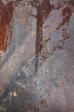 Weathered rusty iron surface with dark brown corrosion, scratches and worn metallic texture. Abstract industrial background for grunge, construction and distressed design concepts.