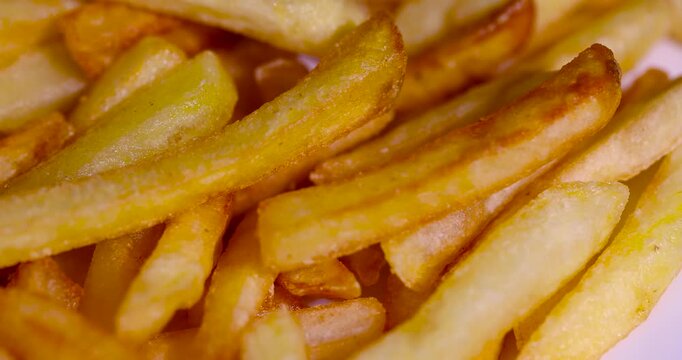 Golden french fries close up, ready crispy french fries lie in a pile after deep frying or air frying until crusted, deep fried