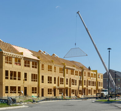 A new neighborhood rises, one framed wall and suspended roof truss at a time.