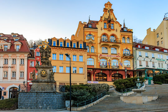 Colorful historic buildings and baroque statue in karlovy vary, czech republic. March 18, 2025, Karlovy Vary, Czech Republic