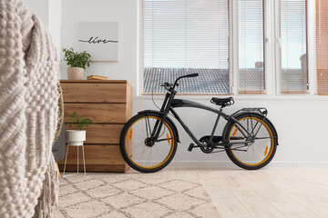 Fototapeta premium Sustainable urban living and eco-friendly transportation, modern bicycle in a bright minimalist apartment interior with wooden furniture