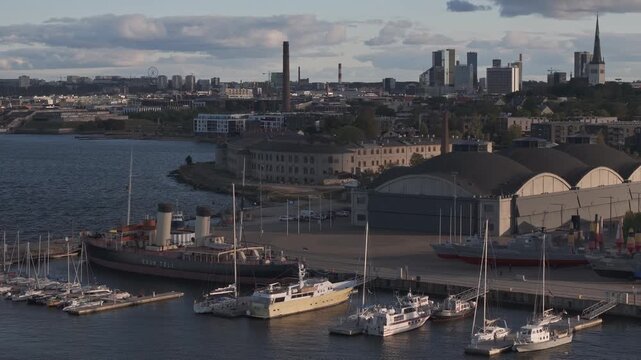 Tallinn, Estonia - September 28, 2025: Seaplane hangars and various boats at Tallinn harbor, with scenic views of the city skyline and waterfront activity, capturing the essence of maritime life.