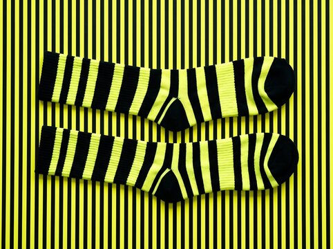 Pair of yellow and black striped socks on matching striped background