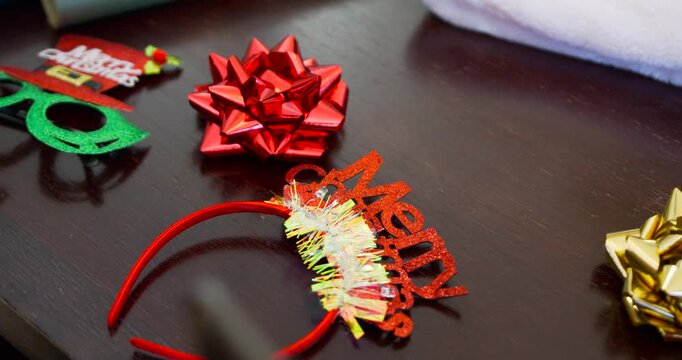 Camera is shifting, showing red headband and green glasses sliding in on dark table for wrapping