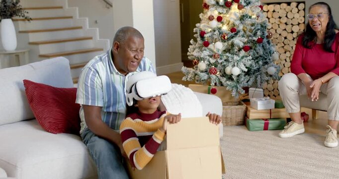African American family youth reacting to VR headset starting, gripping box with man steadying