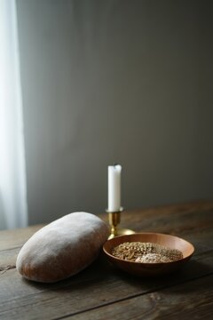Rustic bread, grains, and candle on wooden table